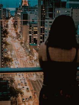 一名女子在夜间俯瞰圣保罗充满活力的城市景观，捕捉着城市的生活与灯光