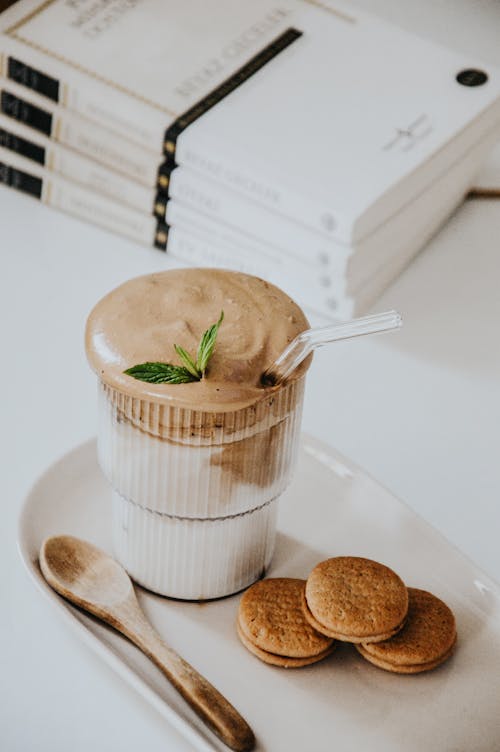 A cup of ice cream with cookies and mint on top