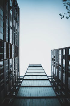 Low angle view of towering modern skyscraper buildings against a clear sky, showcasing urban architecture.