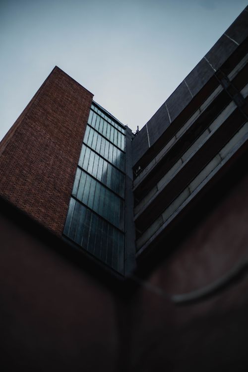 Free Dark and moody angle of a modern building exterior against an overcast sky. Stock Photo