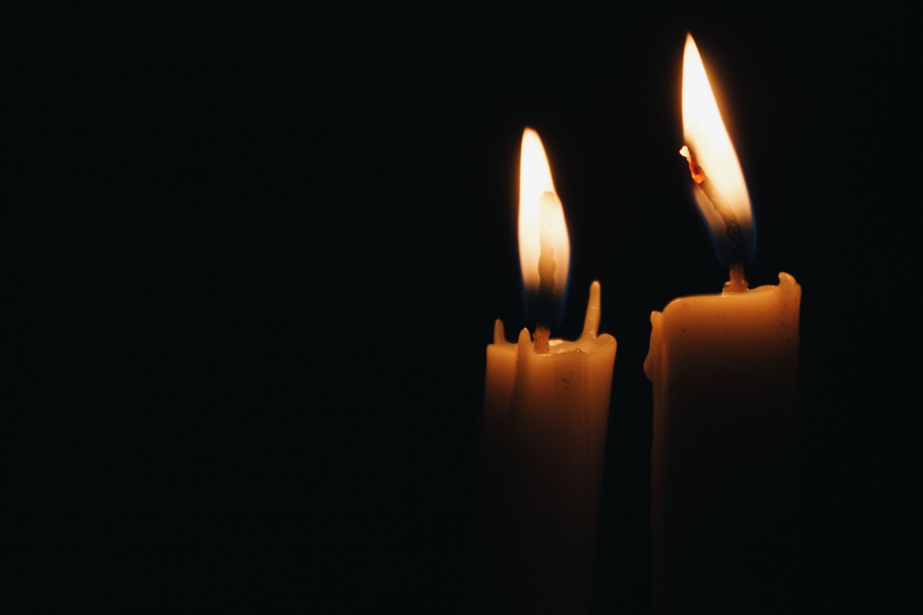 Dos velas encendidas en la oscuridad