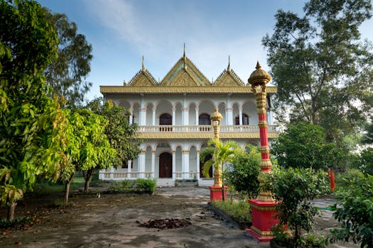 一座宏伟的传统寺庙，金色的屋顶被郁郁葱葱的绿植环绕