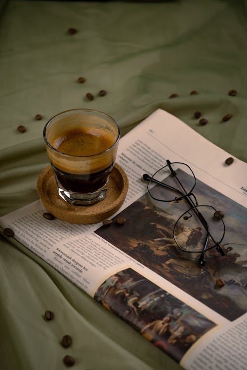 Free A cup of coffee and glasses on a bed Stock Photo