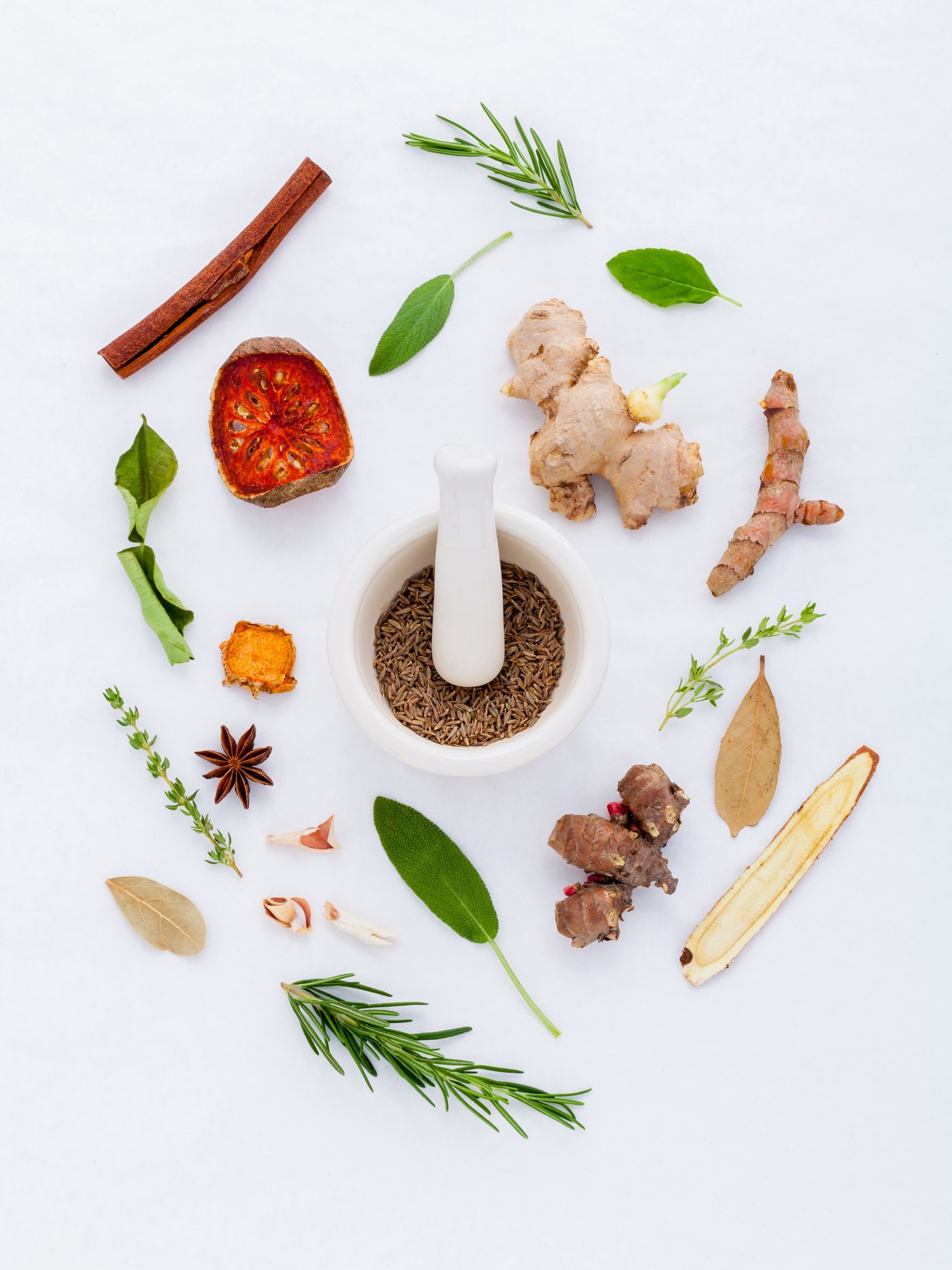 Ayurvedic herbs and spices around a mortar and pestle