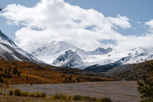 Free Breathtaking view of snowcapped mountains with autumn colors under a partly cloudy sky. Stock Photo