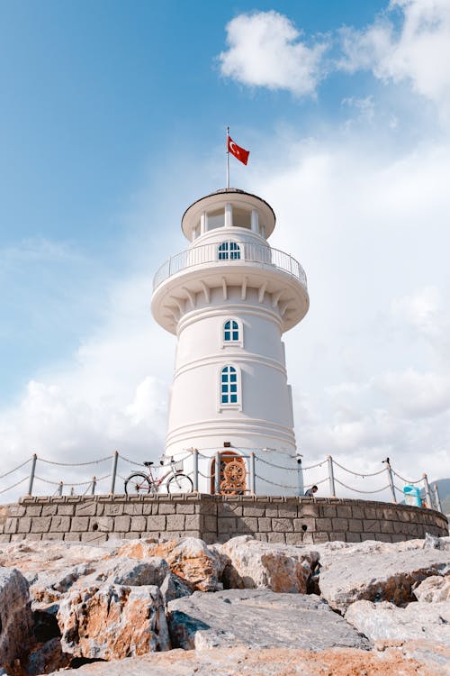 Red Flag On Top Of A White Lighthouse