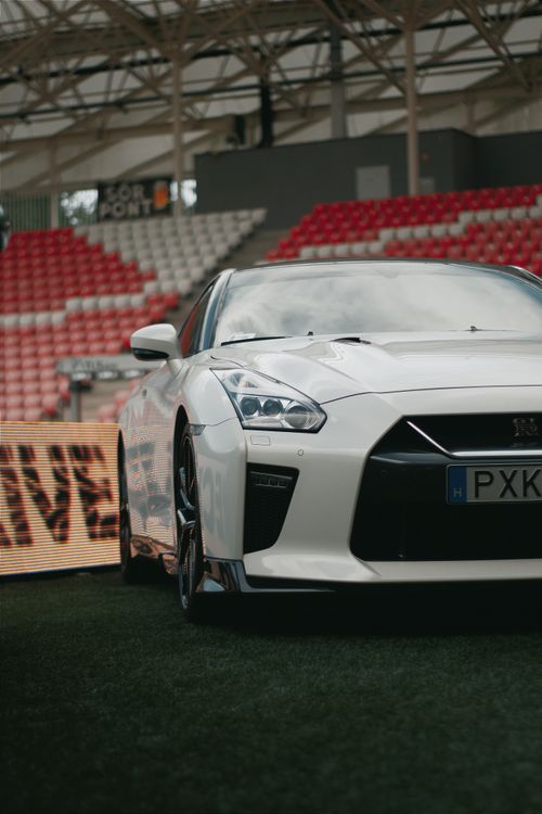 Free A sleek white Nissan GT-R parked in a Hungarian sports stadium, showcasing elegance and power. Stock Photo