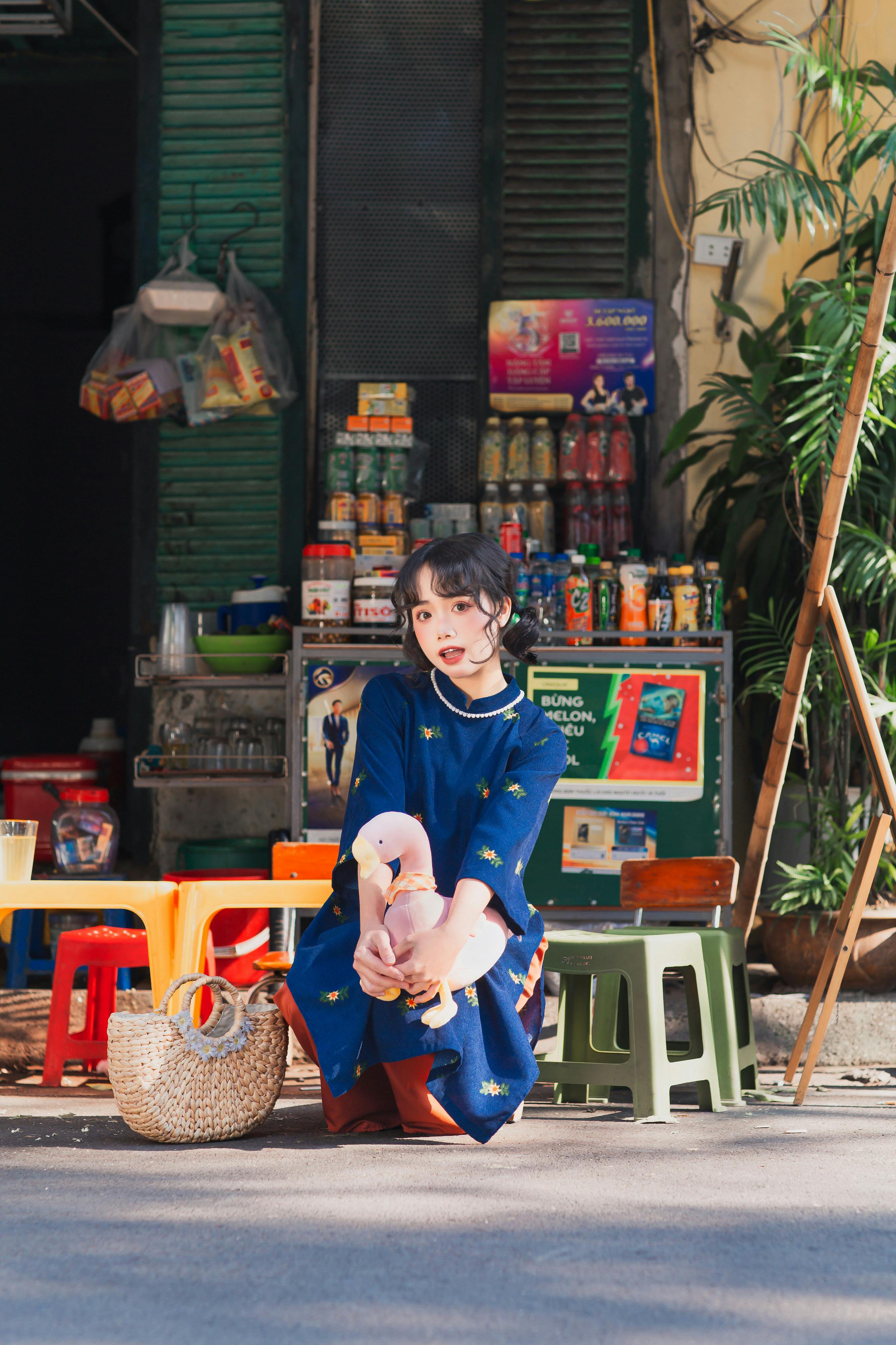 woman in blue dress sitting with teddy toy