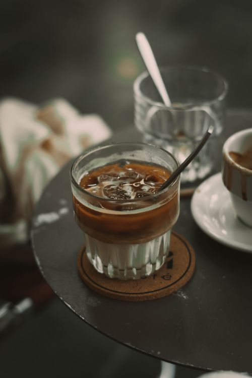 Free Chilled iced latte with ice cubes on a coaster, perfect for summer refreshment. Stock Photo