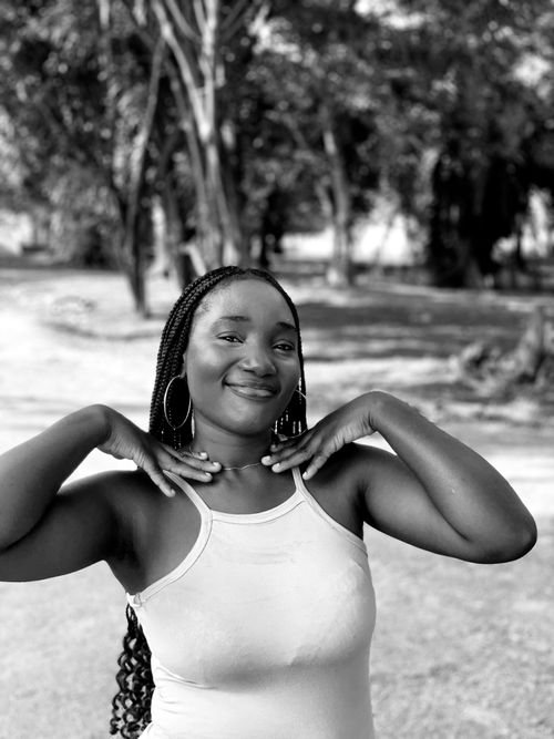 Free Elegant black and white portrait capturing a smiling woman posing outdoors. Stock Photo