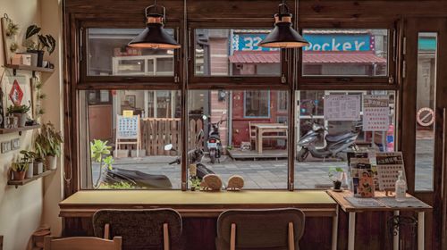 Free Warm café interior with window view of scooters and pedestrian street. Stock Photo