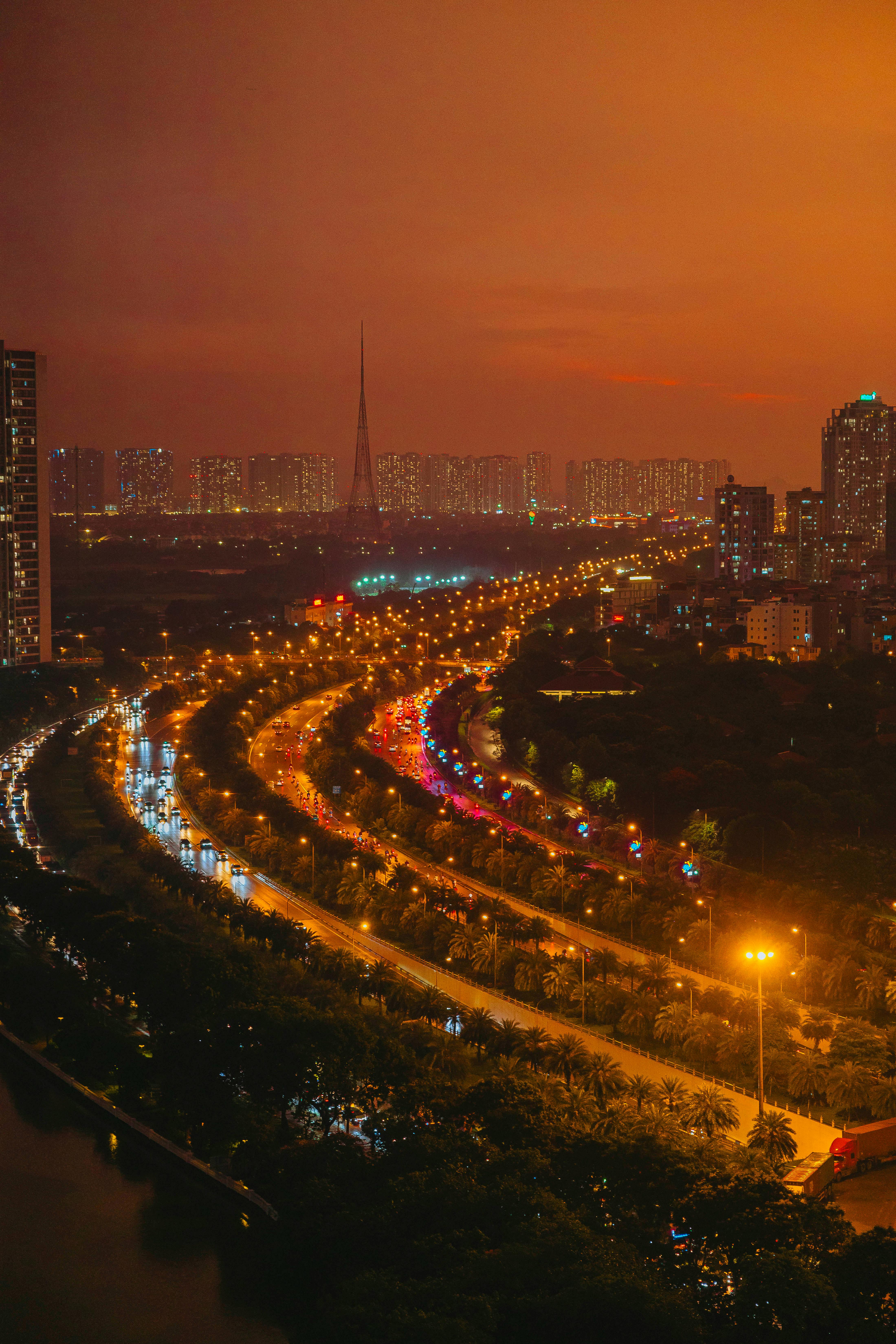 A vibrant night view of Hanoi's cityscape with bustling traffic and illuminated skyscrapers.