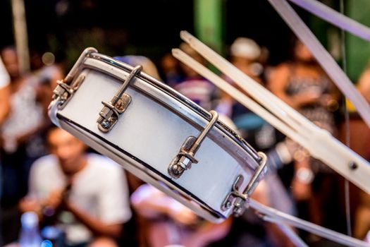 Vibrant close-up of a drum amidst a live concert with people in the background.