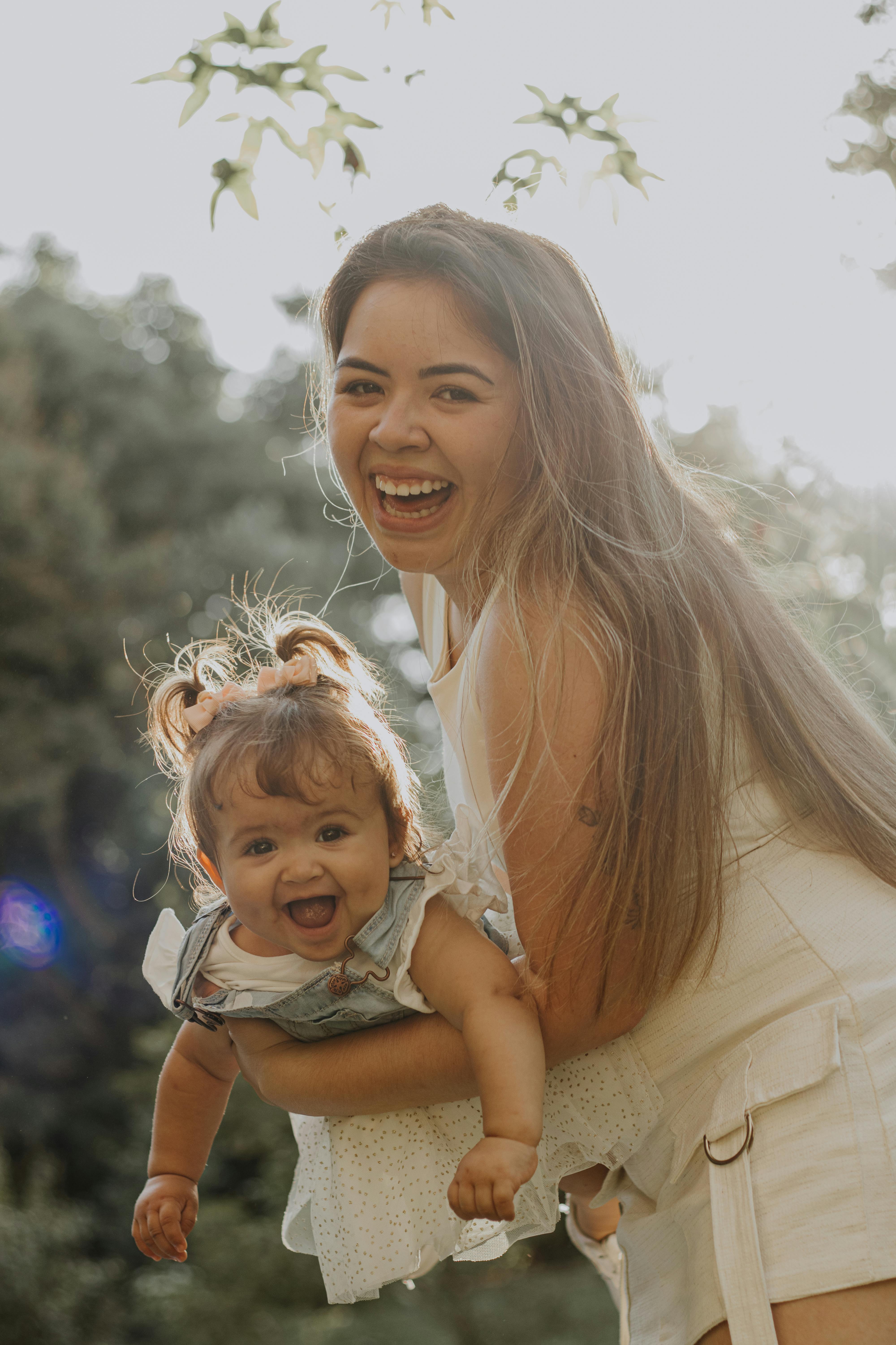 happy blonde mother with daughter in hands