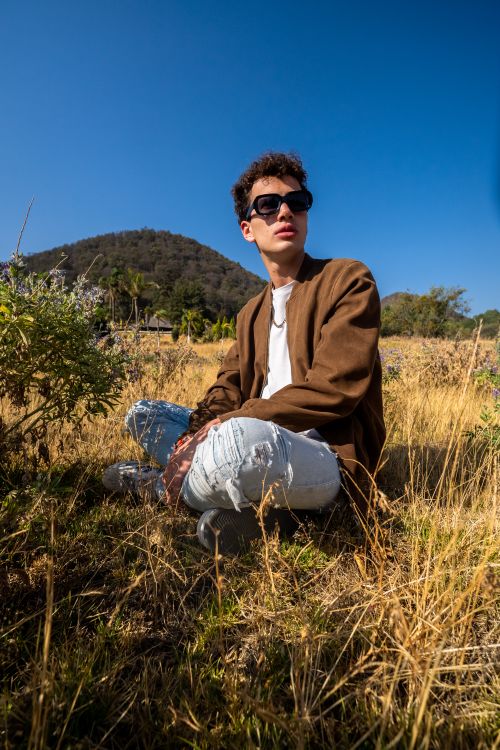 Free Stylish young man in sunglasses posing in a sunny Mexican meadow Stock Photo