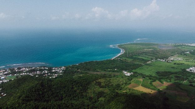Stunning aerial view of Patillas, Puerto Rico coast with lush fields and clear sea, ideal for travel and nature lovers.