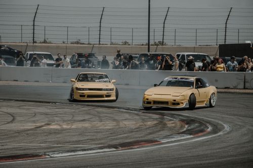 Free Two yellow drift cars in action at a thrilling racing event with spectators watching. Stock Photo