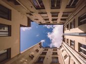 迷人的巴黎庭院向上拍摄，经典建筑映衬着蓝天
