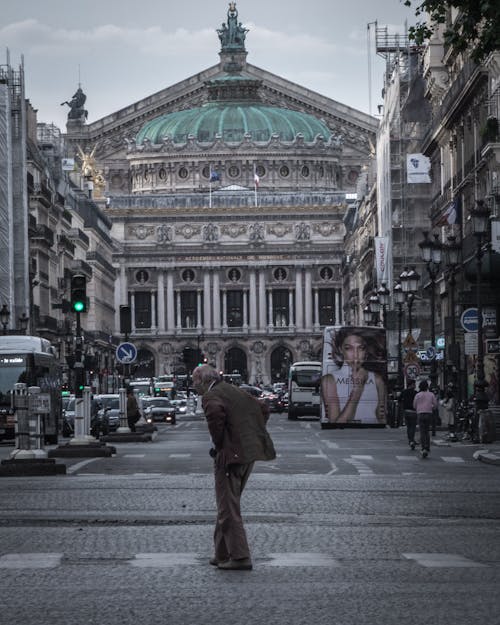 Man Walking in the Middle of the Road Near Vehicles