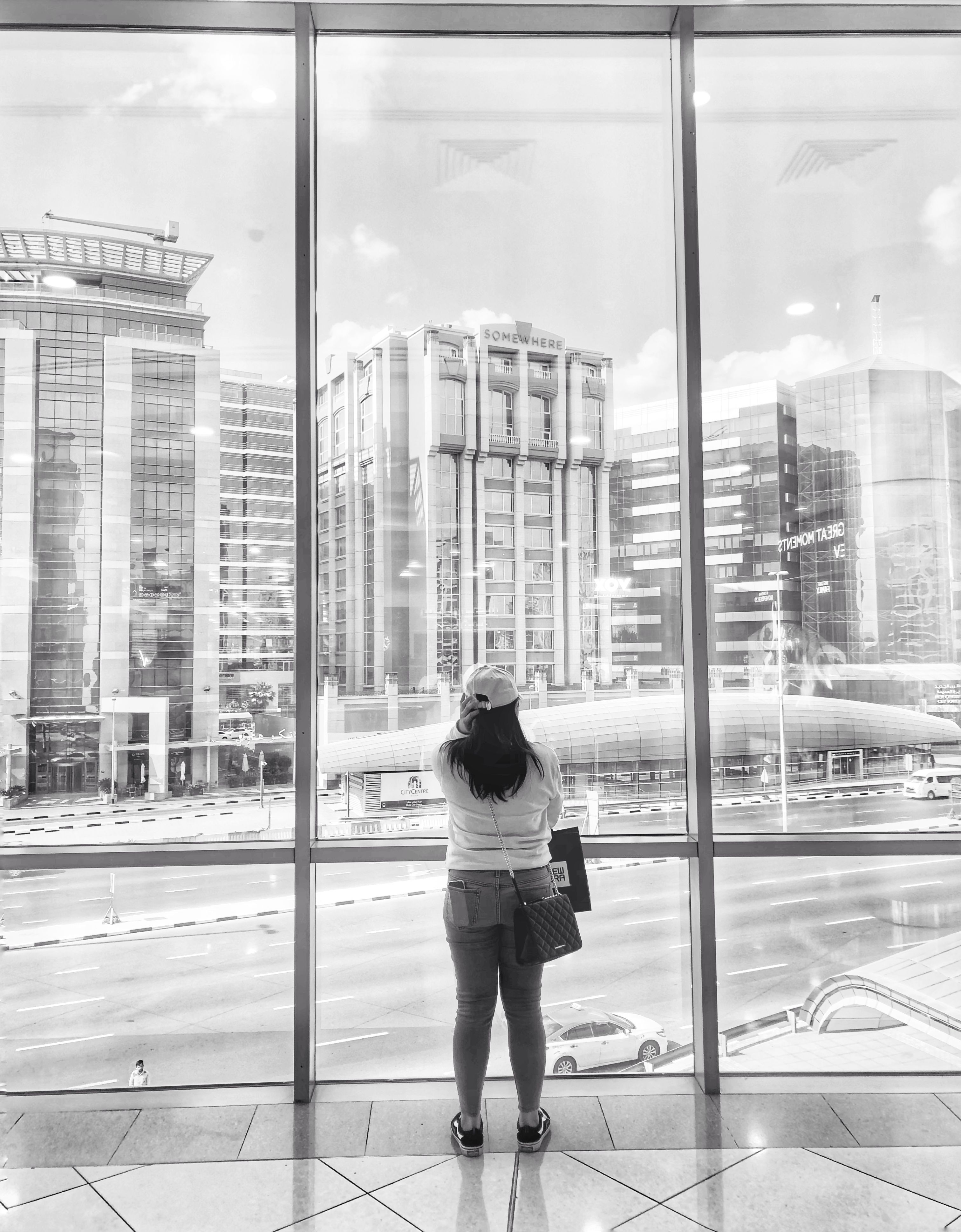 Photographie En Niveaux De Gris D'une Femme Debout Devant Un Miroir