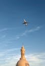 飞机飞越清真寺圆顶，背景清晰，天空宁静