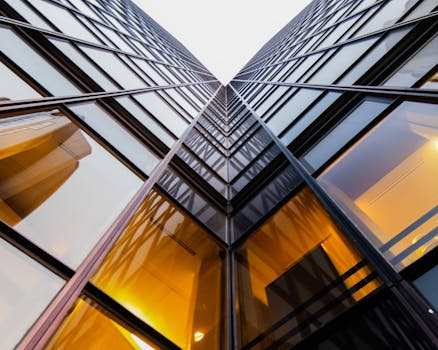 这是一张巴黎现代玻璃建筑的低角度视图，其几何图案与倒影引人注目