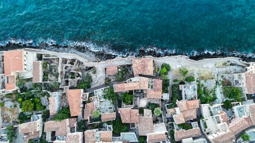 Free Stunning aerial shot of the coastal city Μονεμβασιά, Greece showcasing traditional architecture and the vibrant sea. Stock Photo