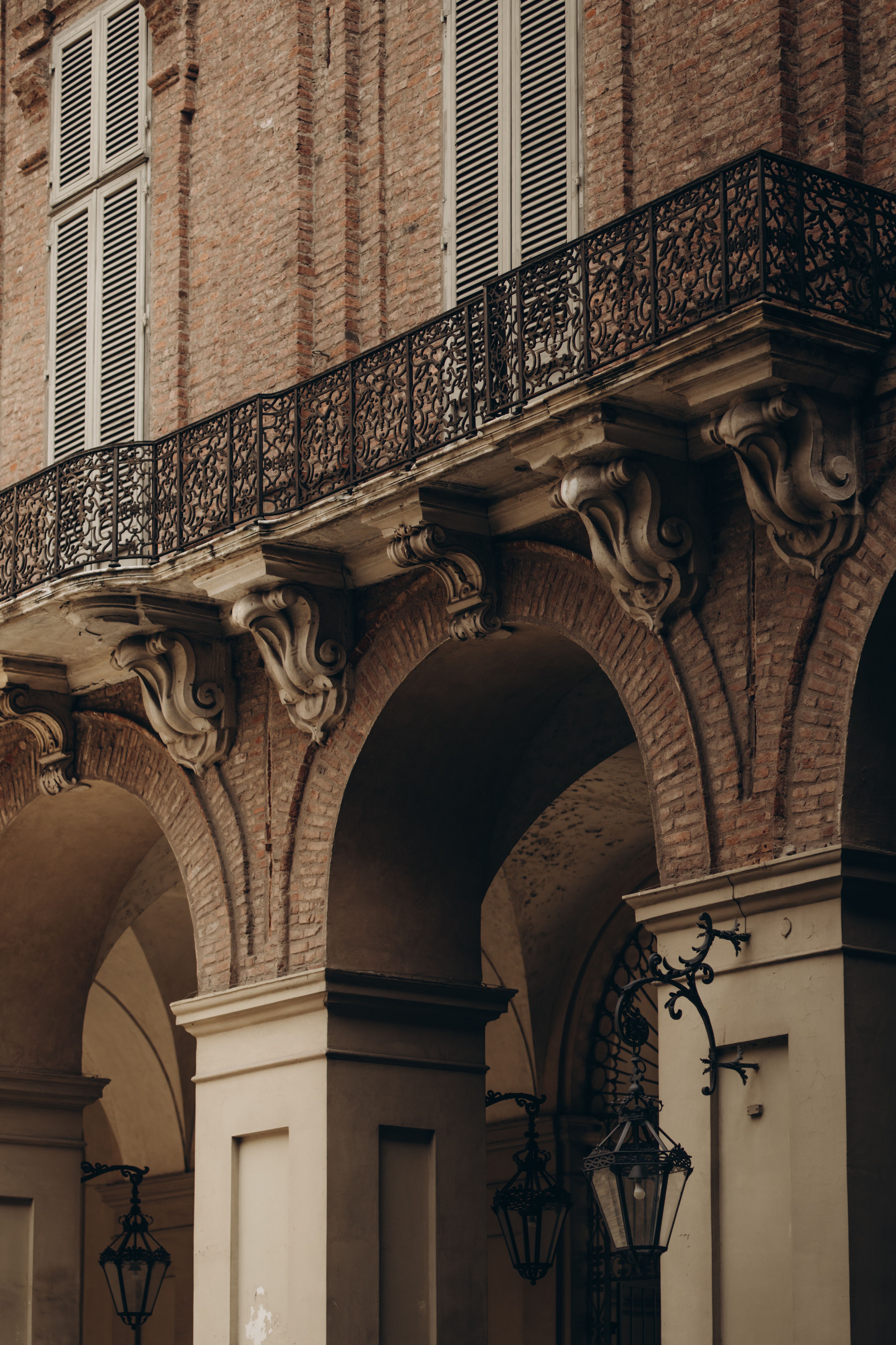 A close-up view of elegant vintage architecture featuring arches and ornate balconies.