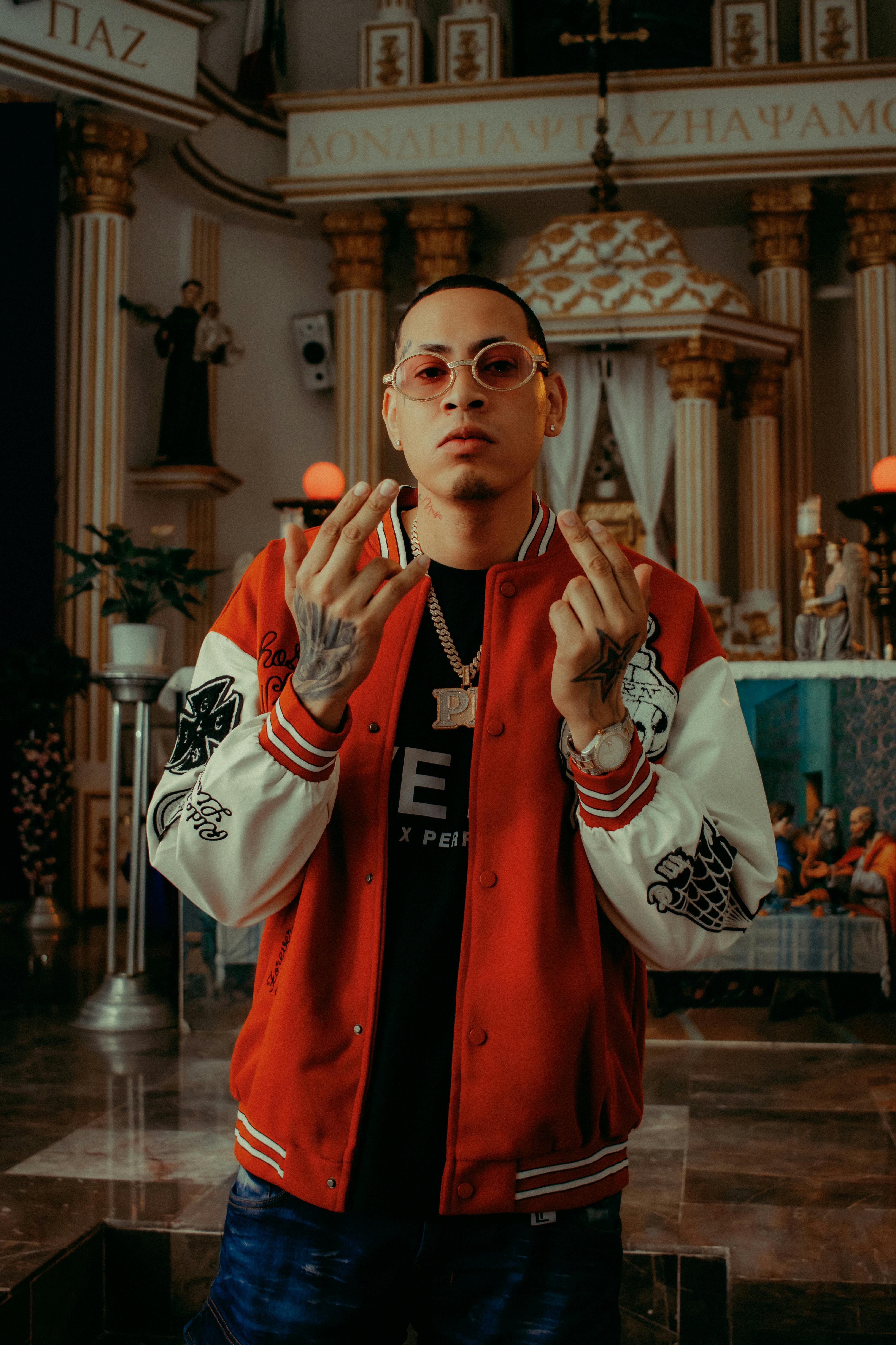 Fashionable man in red jacket posing confidently indoors with elegant church background.