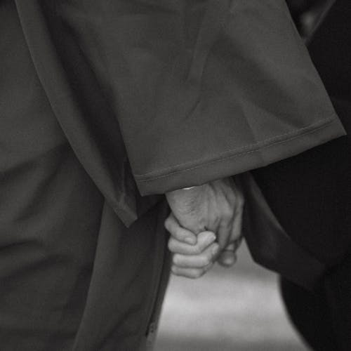 A black and white photo of a couple holding hands