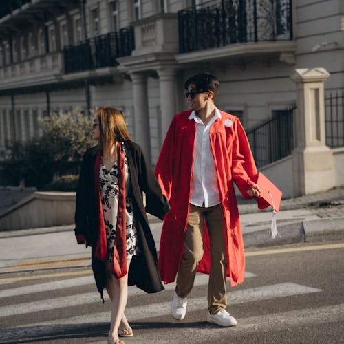 Foto profissional grátis de andando, casal, chapéu acadêmico