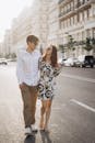 Man in Shirt and Woman in Sundress on Street