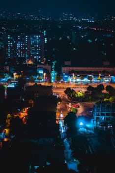 Stunning aerial view of an urban cityscape illuminated at night with vibrant lights.