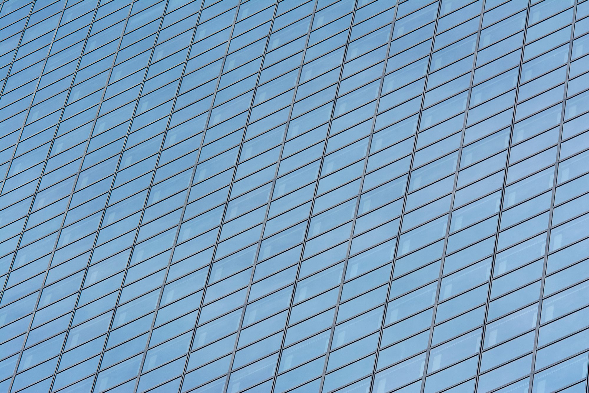 A blue glass building facade with geometric reflections