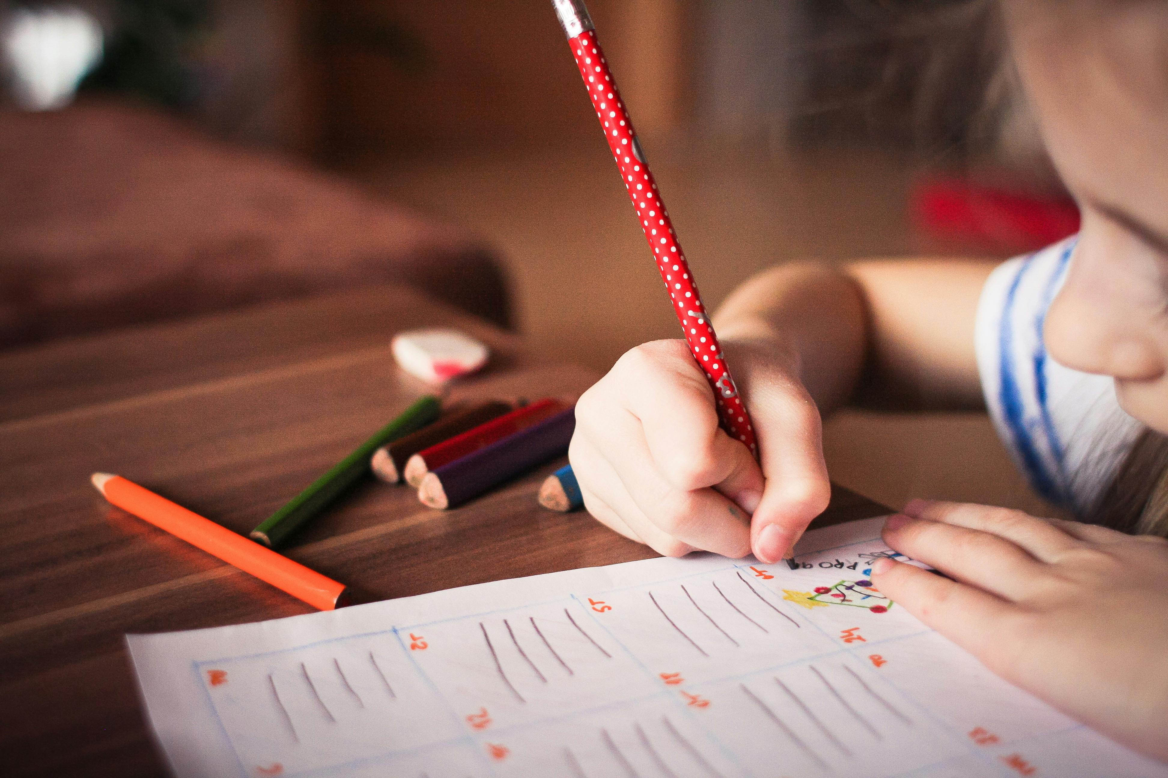 Little girl writing at the desk. | Photo: Pexels