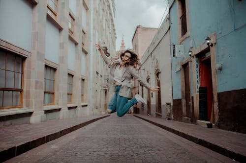 Woman Jumping Near Buildings