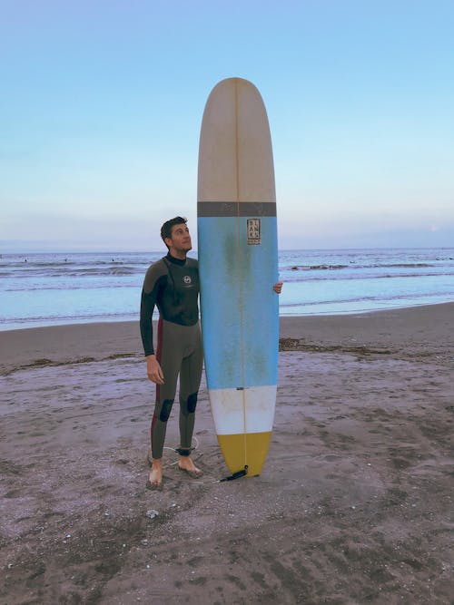 Man molding surfboard on the beach