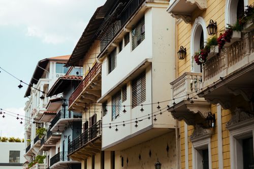 Free Beautiful urban residential buildings with balconies and hanging lights, showcasing classic architecture. Stock Photo