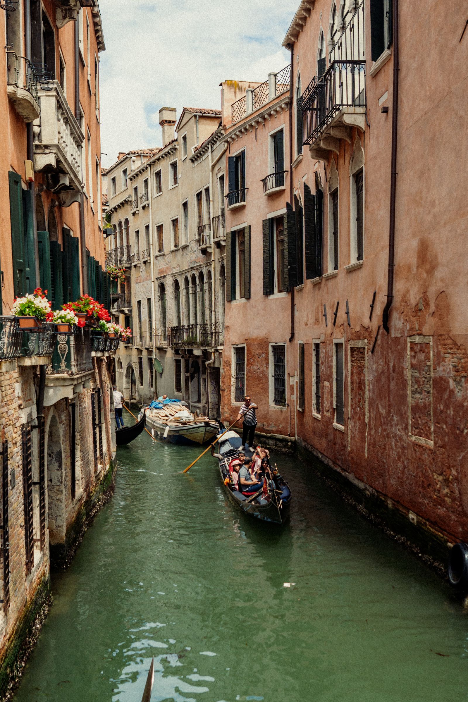 Gondolas on a narrow canal between apartment buildings in Venice
