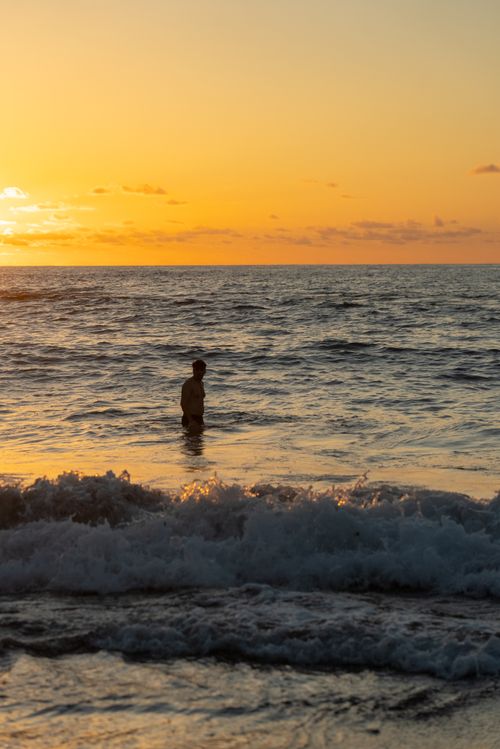 Free A serene silhouette of a man standing in the sea at sunset, capturing calmness and beauty in Puerto de la Cruz, Spain. Stock Photo