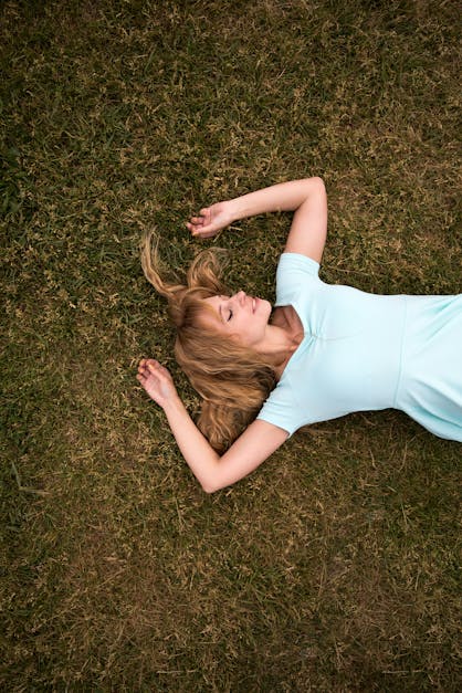 Woman Lying On Her Back On The Grass With Her Eyes Closed · Free Stock