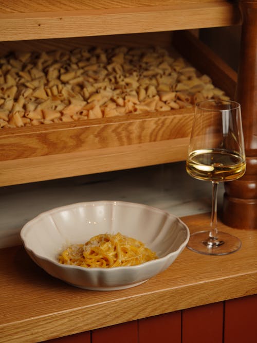 A bowl of pasta and a glass of wine