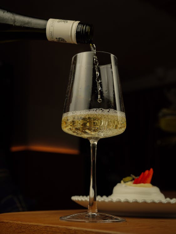 A person pouring wine into a glass