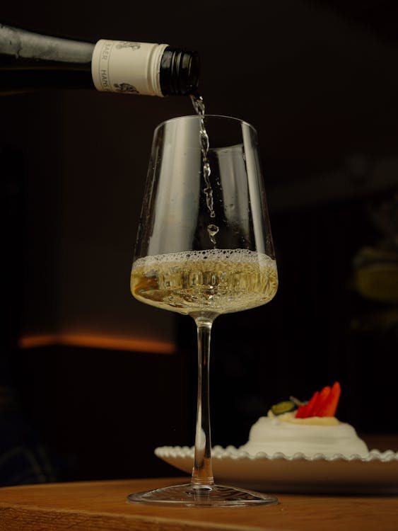 A person pouring wine into a glass