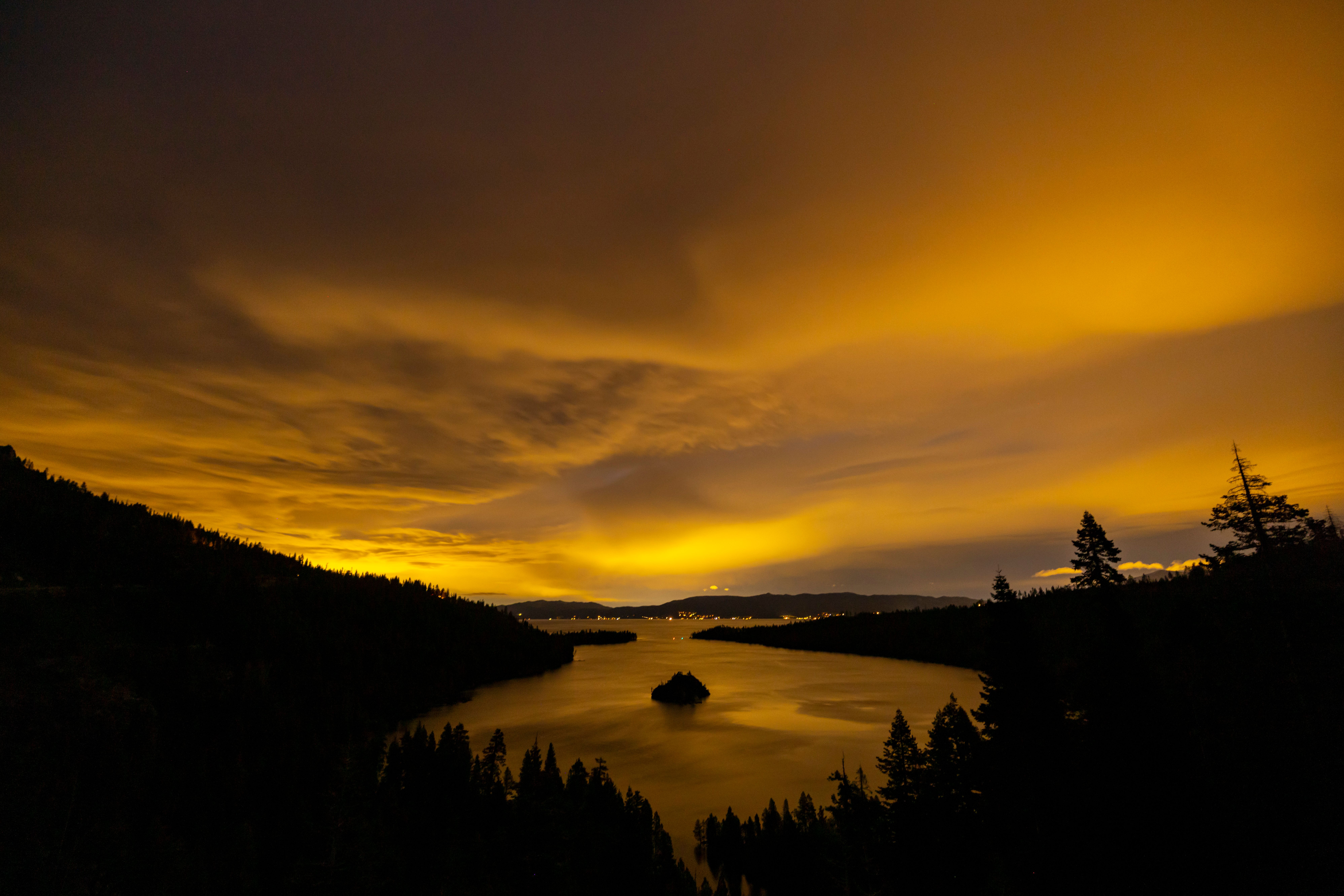 A yellow sky with clouds over a lake · Free Stock Photo