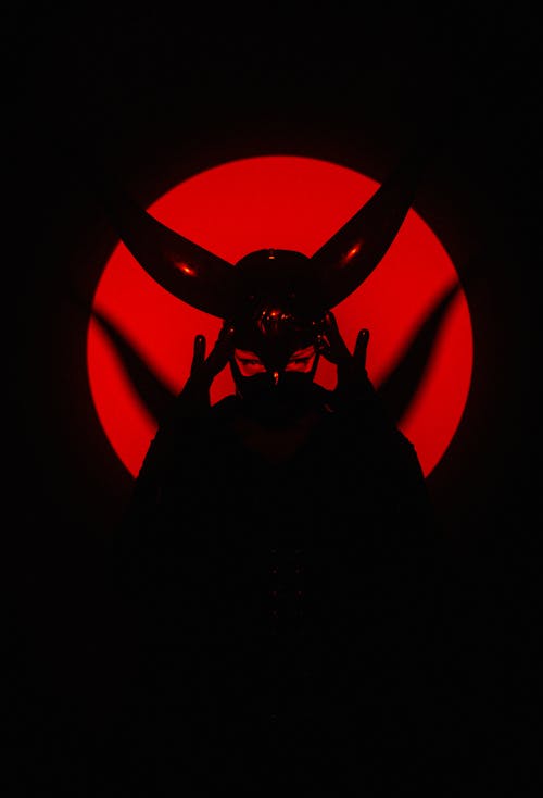 A man in a mask with red light behind him