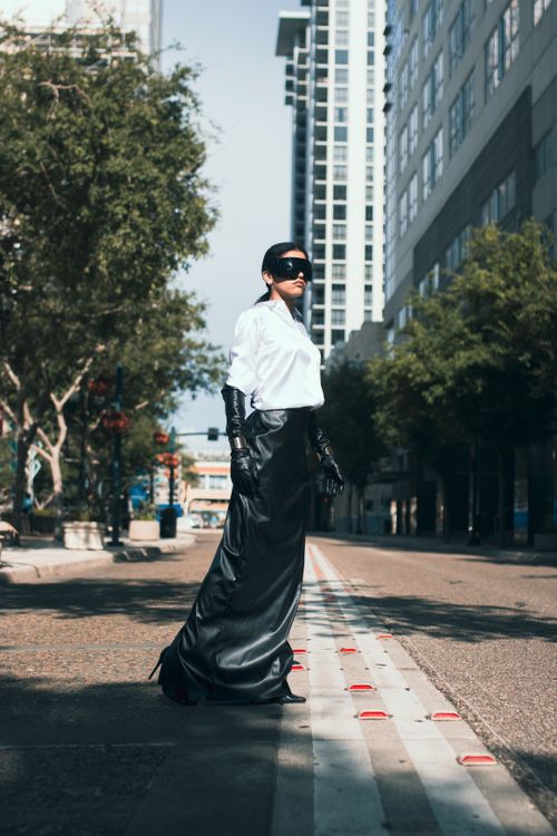 Free Stylish woman in urban fashion on a city street with skyscrapers. Stock Photo
