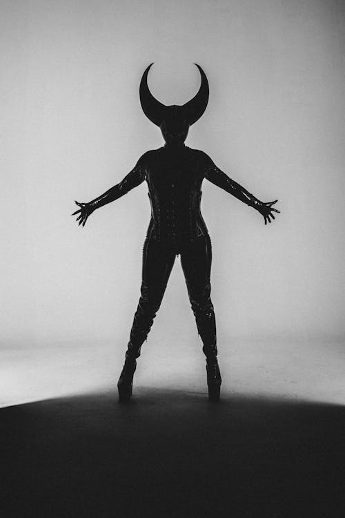 A woman in a black and white silhouette with horns