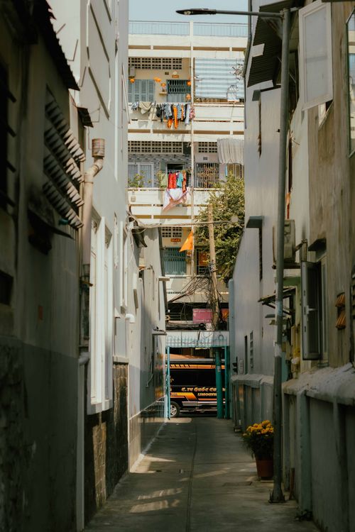Free Narrow urban alleyway in Ho Chi Minh City showing daily life with laundry and residential buildings. Stock Photo