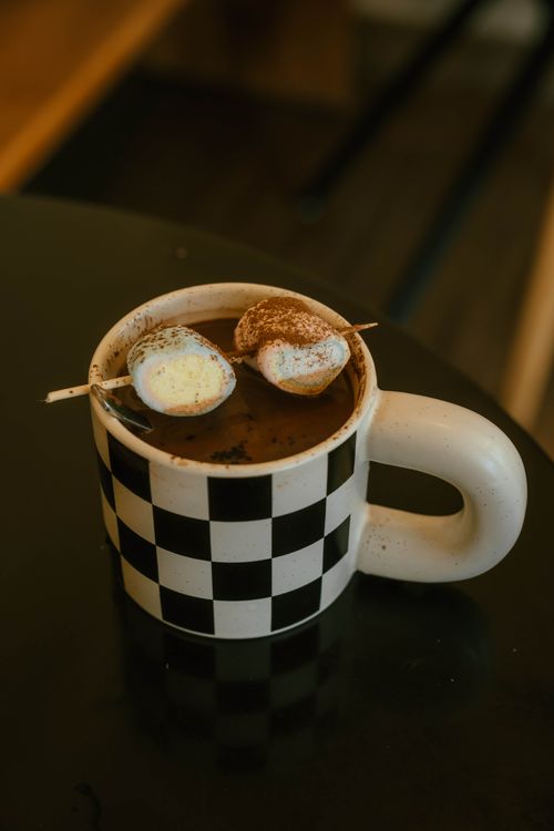 Free Close-up of hot chocolate with marshmallows served in a checkered mug. Stock Photo